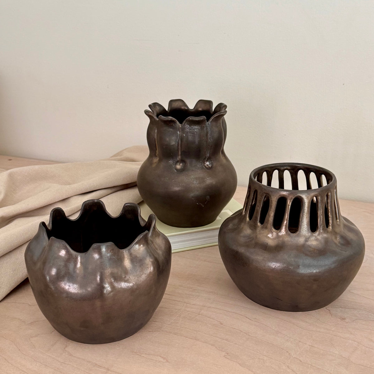 Three handmade bronze-black stoneware vases grouped together